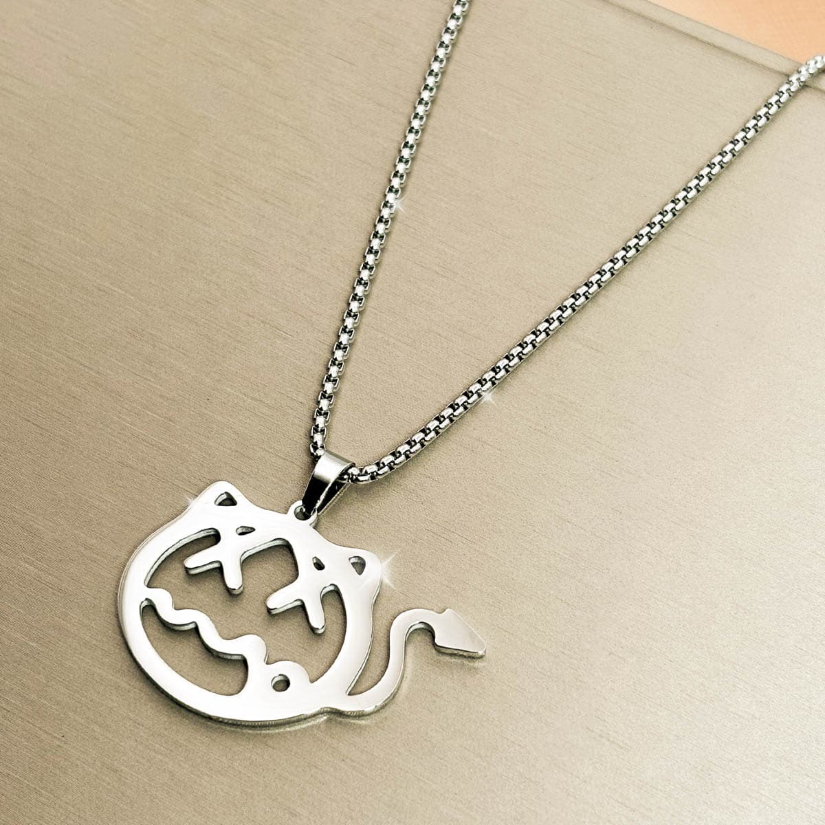 Kreative Herren-Kette aus Edelstahl in Silber mit ausgeschnittenem Teufelchen-Motiv, Detail-Aufnahme. von links