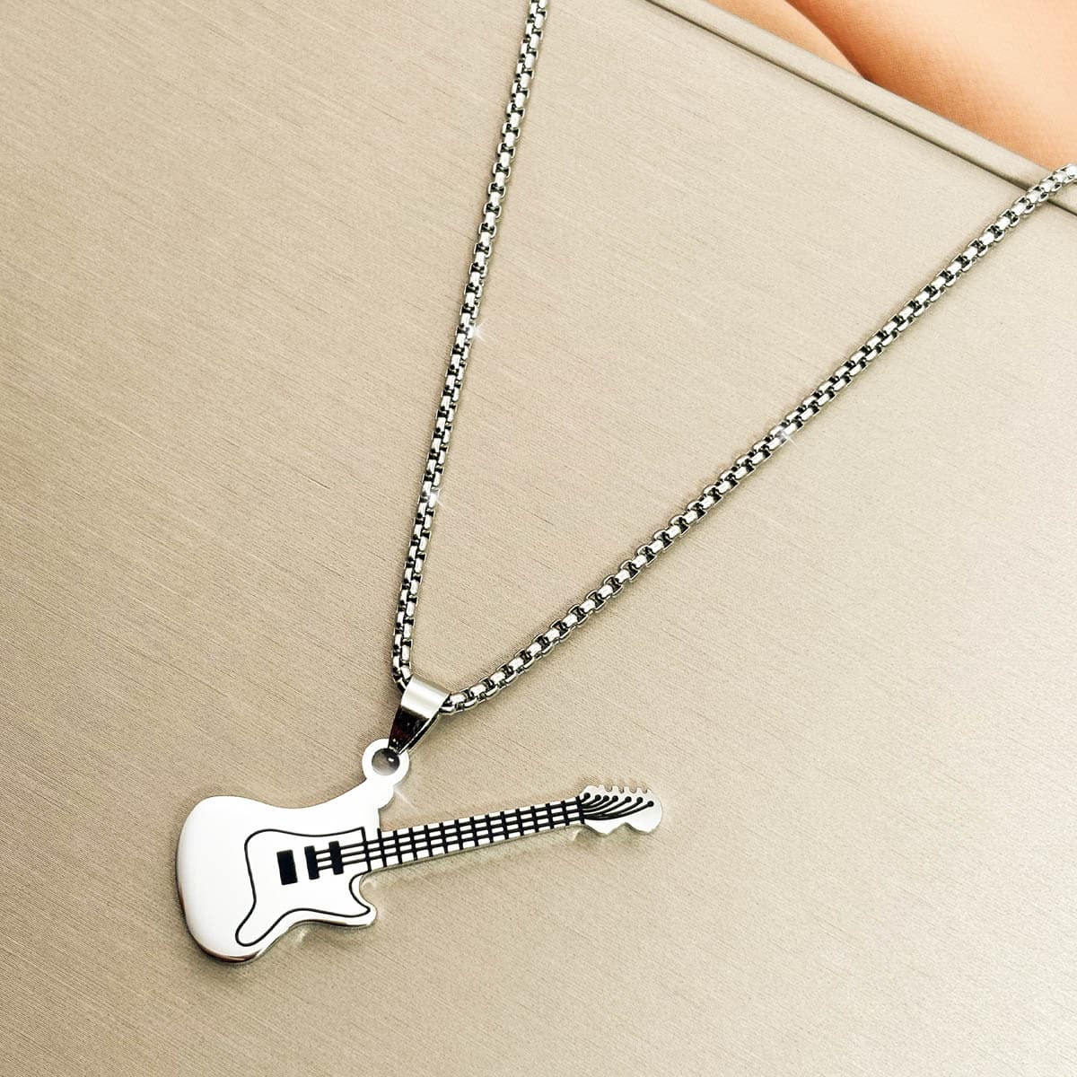 Herren Halskette aus silberfarbenem Edelstahl mit einem E Gitarren Anhänger, Produktfoto von links