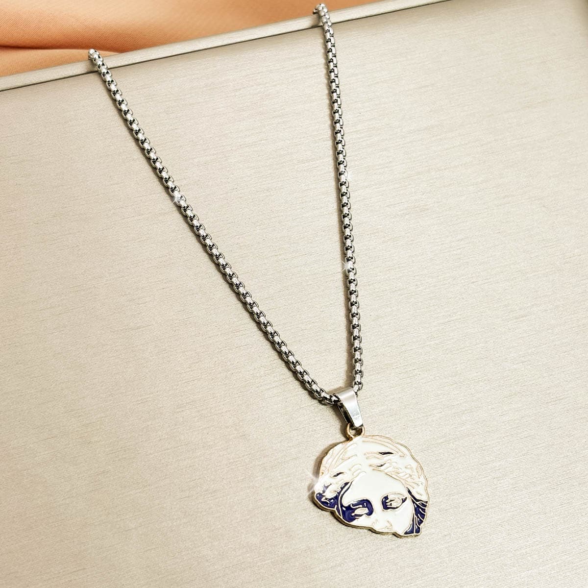 Herren-Kette aus Edelstahl in Silber mit einem runden Anhänger im antiken Porträt-Design, Detail-Aufnahme.