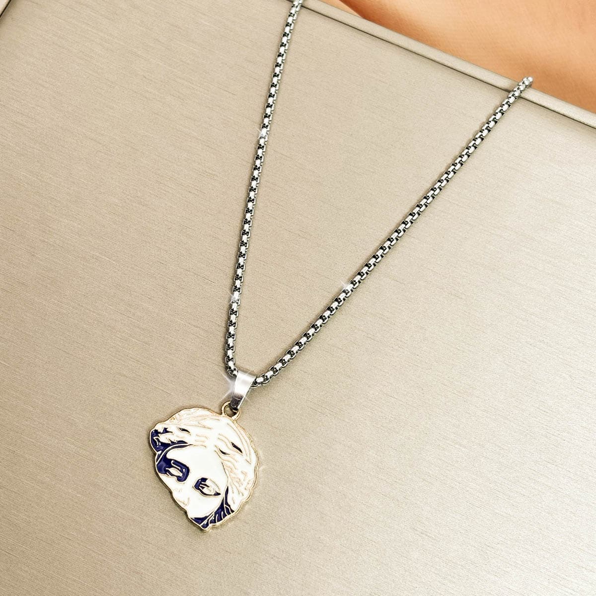 Herren-Kette aus Edelstahl in Silber mit einem runden Anhänger im antiken Porträt-Design, Detail-Aufnahme von links