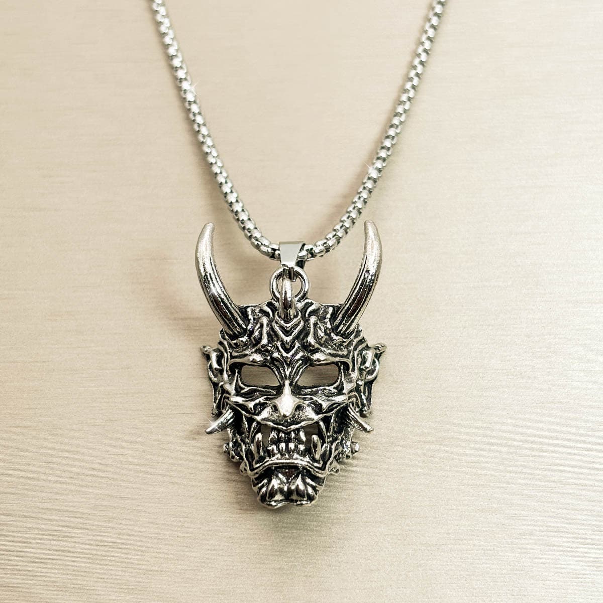 Herren Halskette mit markantem Oni-Masken-Anhänger im japanischen Stil aus silberfarbenem Edelstahl, Produktfoto.