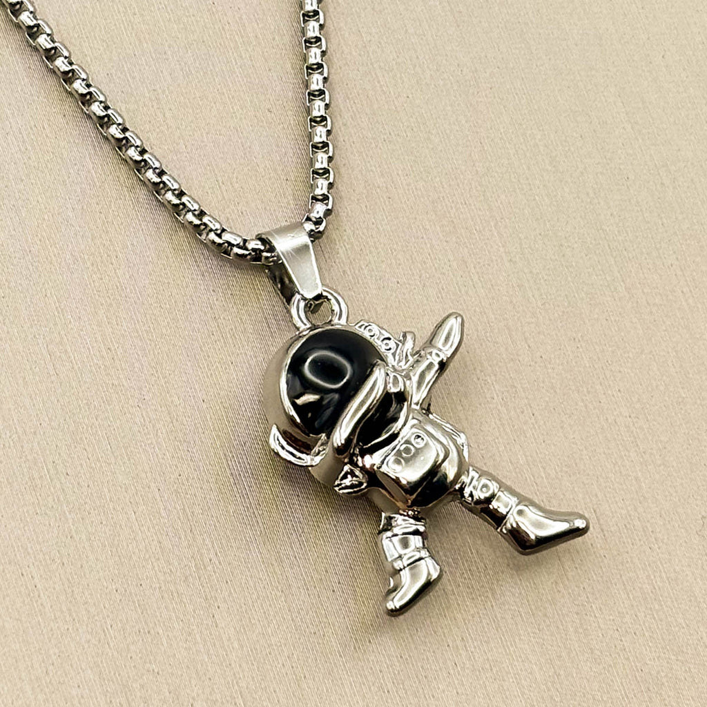 Silberfarbene Edelstahl-Halskette für Herren mit einem Astronauten-Anhänger in Dab-Pose und schwarzem Visier, Studioaufnahme.