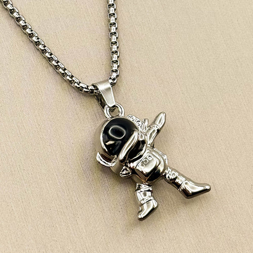 Silberfarbene Edelstahl-Halskette für Herren mit einem Astronauten-Anhänger in Dab-Pose und schwarzem Visier, Studioaufnahme.