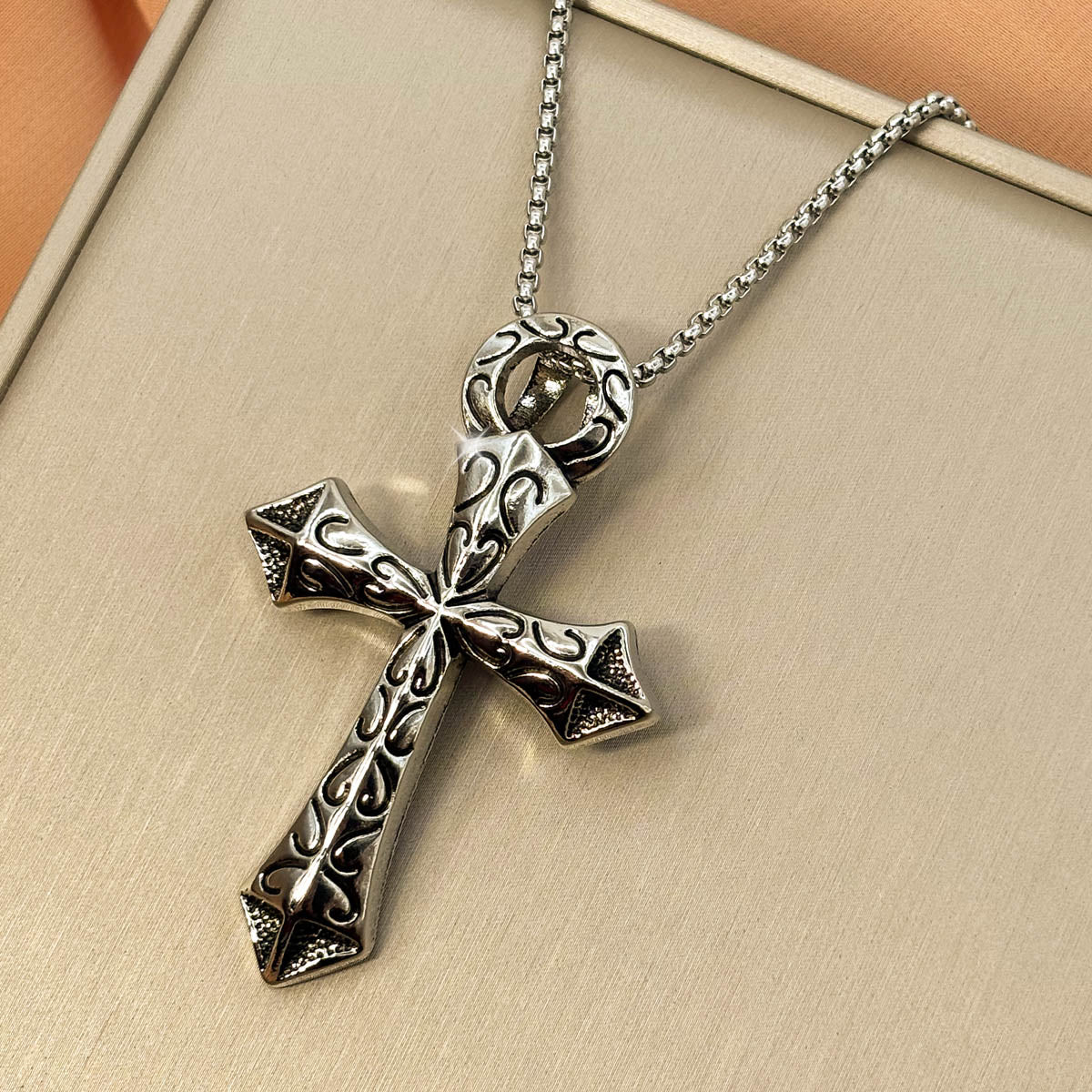Silberfarbene Herren-Halskette aus Edelstahl mit einem verzierten ägyptischen Ankh-Kreuz-Anhänger samt Hieroglyphen-Struktur, Produktfoto.