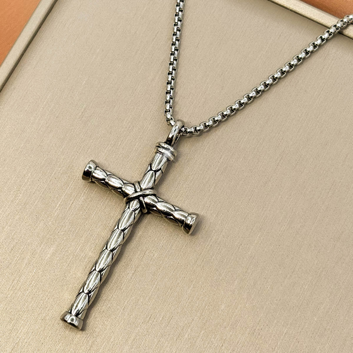 Silberfarbene Edelstahl-Halskette für Herren mit einem strukturierten Kreuz-Anhänger im antiken Look, Studioaufnahme.