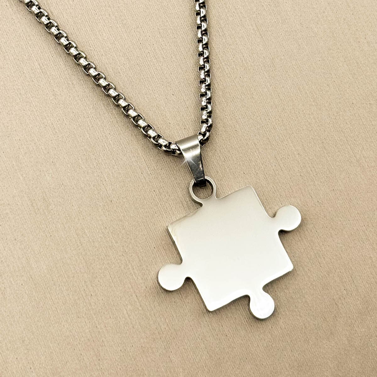 Silberfarbene Herren Halskette aus Edelstahl mit einem Partner Puzzle Anhänger, Nahaufnahme von links.
