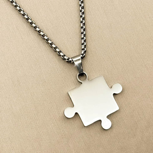 Silberfarbene Herren Halskette aus Edelstahl mit einem Partner Puzzle Anhänger, Nahaufnahme von links.