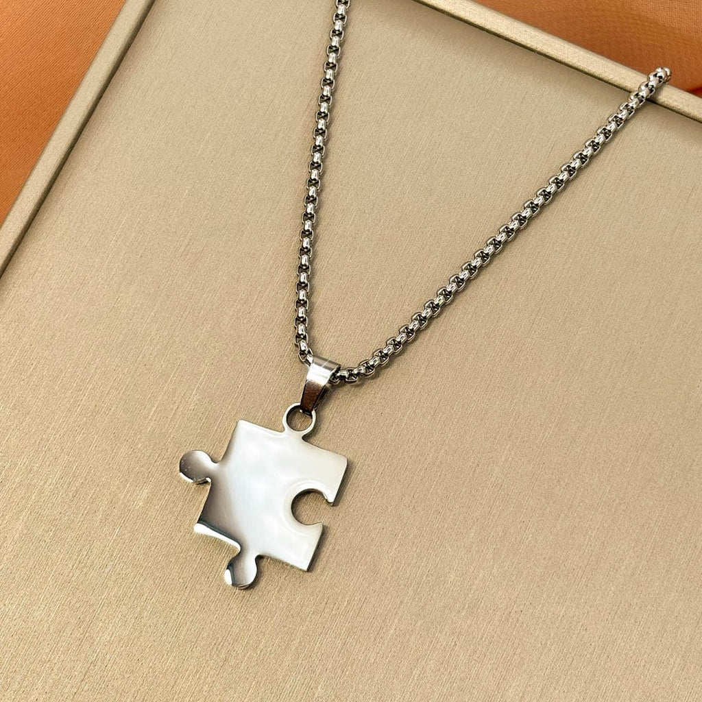 Silberfarbene Herren Halskette aus Edelstahl mit einem Partner Puzzle Anhänger, Nahaufnahme von links.