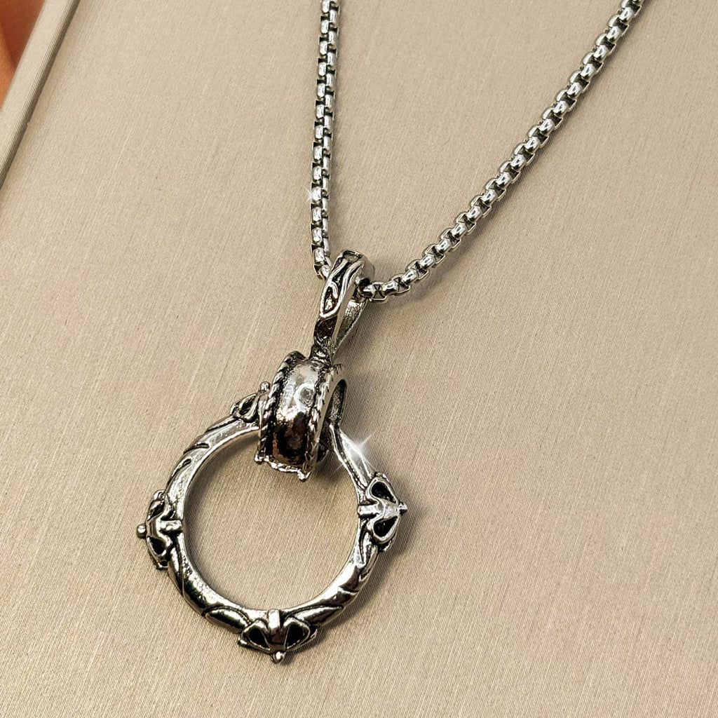 Silberfarbene Edelstahl Herrenkette mit einem Gothic Ring Anhänger, Studioaufnahme von rechts.