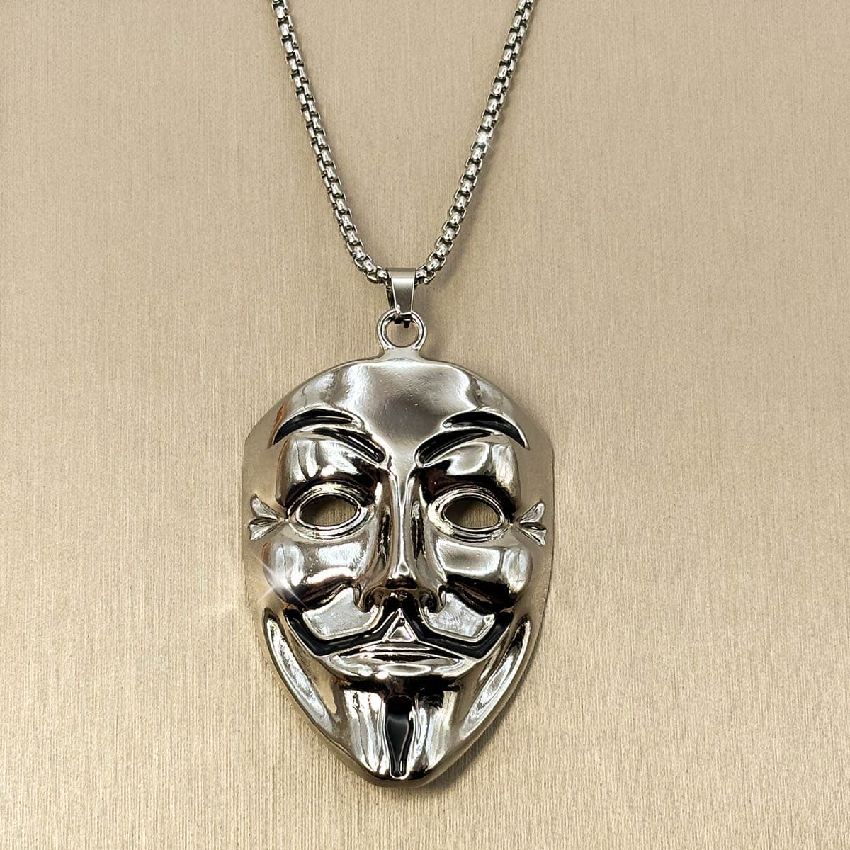 Edelstahl Herrenkette in Silber mit glänzendem Anhänger im Design einer Maske, Nahaufnahme.