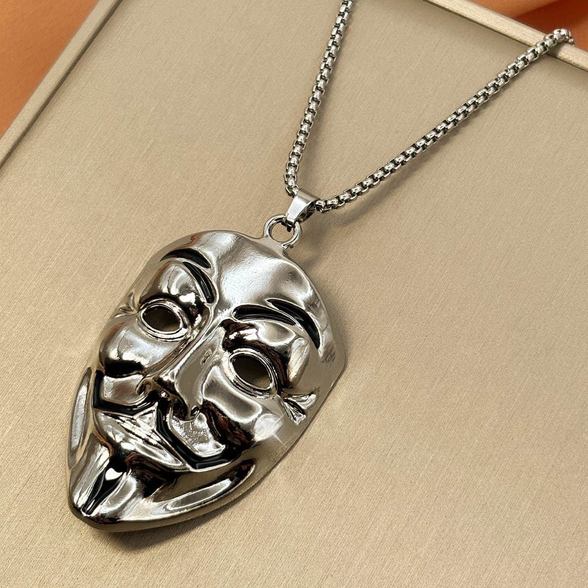 Edelstahl Herrenkette in Silber mit glänzendem Anhänger im Design einer Maske, Nahaufnahme von rechts.