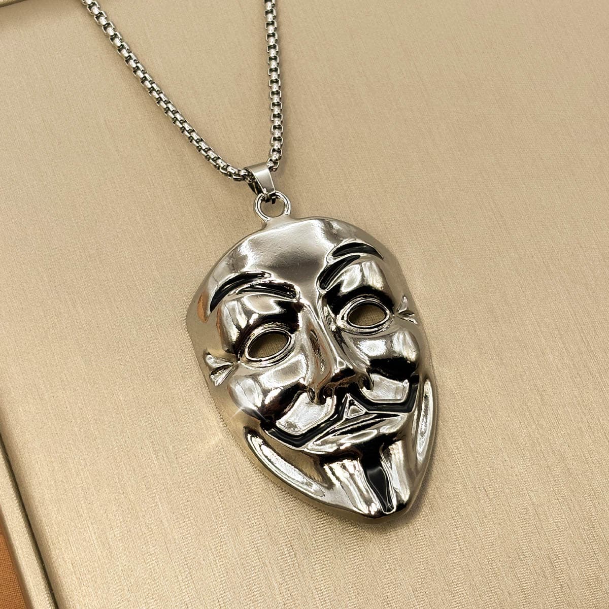 Edelstahl Herrenkette in Silber mit glänzendem Anhänger im Design einer Maske, Nahaufnahme von links